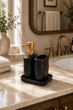 Load image into Gallery viewer, Black Sculpted Calm three-piece ceramic bathroom set with 350 ml gold-toned pump soap dispenser, matching tumbler and rectangular tray.