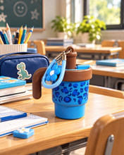 Load image into Gallery viewer, Electric Blue leopard-print water bottle with brown handle, blue carrying strap and flower charm on a classroom desk.