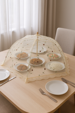 Load image into Gallery viewer, 30-inch floral mesh food cover umbrella placed over plates on a wooden dining table
