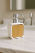Load image into Gallery viewer, Minimalist bamboo and ceramic soap dispenser on marble bathroom counter