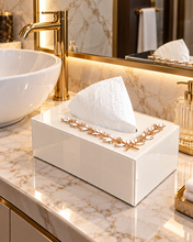 Load image into Gallery viewer, White glass tissue box with crystal-style gold-tone leaf detailing on a vanity countertop
