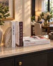 Load image into Gallery viewer, 4 piece decorative faux book set displayed on illuminated floating shelf with knot sculpture