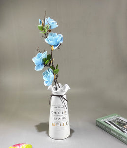 Artificial flower arrangement in quoted ceramic vase
