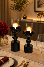 Load image into Gallery viewer, Black floral metal candle holder set with glass hurricane shades and decorative pedestal base
