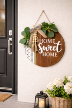 Load image into Gallery viewer, Round wooden Home Sweet Home hanging sign with greenery and rustic accents on entry wall
