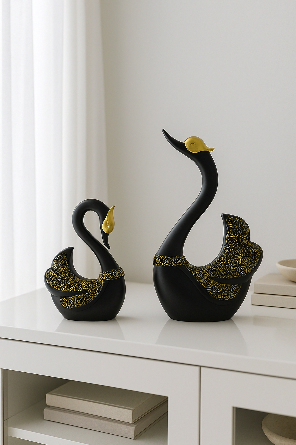 Swan couple resin figurines in black and gold placed on a white table