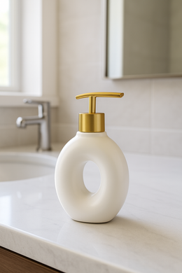 White ceramic soap dispenser with gold pump on bathroom counter from MetaphorBD.