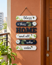 Load image into Gallery viewer, Bless This Home floral welcome sign with black and white panels, green leaves and bee artwork on a terracotta entrance wall – Metaphor BD
