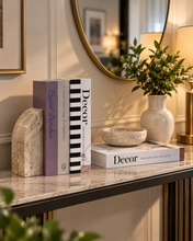 Load image into Gallery viewer, 4 piece neutral decorative faux book set stacked on marble coffee table in bright living room
