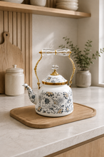 Load image into Gallery viewer, Floral enamel tea kettle in white with blue-grey floral pattern, gold-tone detailing and crystal-style accents, available in 1-liter and 2.4-liter capacities.
