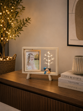 Load image into Gallery viewer, Display your favorite memories with this battery-operated LED wooden photo frame featuring warm tree lights and adorable couple figurines. Perfect for bedrooms, living rooms, and thoughtful gifts.
