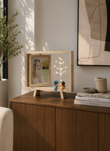 Load image into Gallery viewer, Display your favorite memories with this battery-operated LED wooden photo frame featuring warm tree lights and adorable couple figurines. Perfect for bedrooms, living rooms, and thoughtful gifts.
