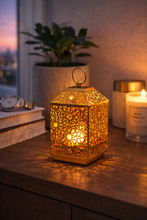 Load image into Gallery viewer, Gold metal decorative lantern with geometric cutwork design on table
