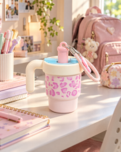 Load image into Gallery viewer, Powder Blue leopard-print water bottle with cream handle, blue carrying strap and flower charm on a pastel study desk.
