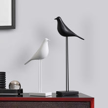Load image into Gallery viewer, Black and white bird figurines on stands used as minimalist Nordic decor on red console table
