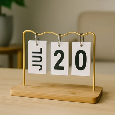 Minimalist desk flip calendar with JUL 20 displayed on wooden base and gold frame

