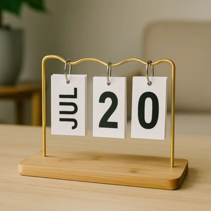 Minimalist desk flip calendar with JUL 20 displayed on wooden base and gold frame

